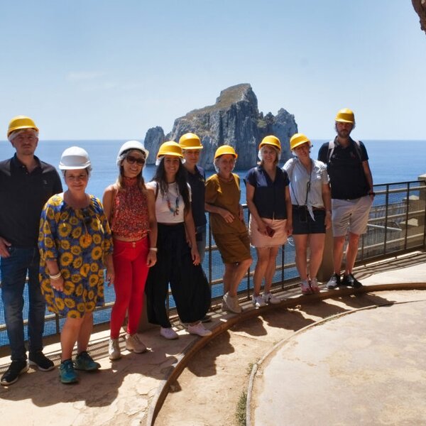 Groupe de personnes avec casques de sécurité lors d'une visite côtière rocheuse