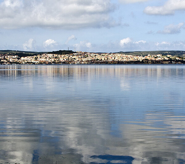 Vue d'une ville en arrière-plan avec reflets sur l'eau calme.