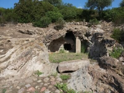 Entrée d'une grotte creusée dans la roche entourée de végétation