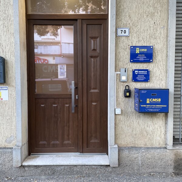 Brown entrance door with blue plaques and credential box number 70